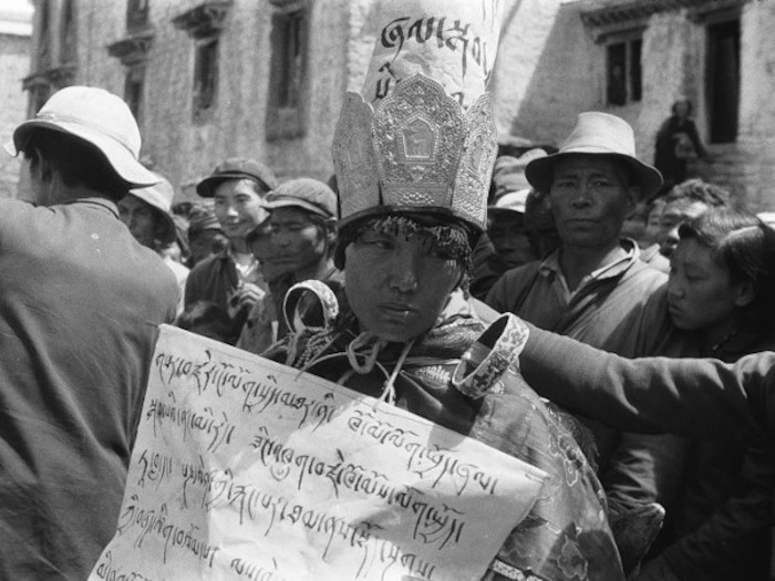 A Buddhist nun wears a sign labeling her as a counterrevolutionary